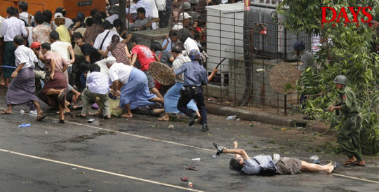 民主化を求めるデモを鎮圧するために発砲した兵士たちと、銃撃され街頭に倒れる映像ジャーナリスト長井健司さん（50歳）。地面に倒れながらも撮影を続けようとしている状況が伝わる。長井さんは、この直後に死亡した。2007年9月27日　ヤンゴン・ビルマ　DAYS国際フォトジャーナリズム大賞　DAYS特別賞「孤立するビルマ」アドリース・ラティーフ