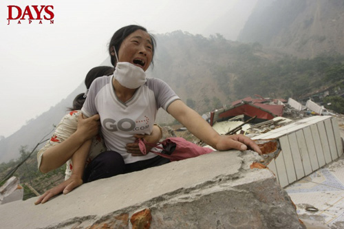 娘と夫が見つからず、倒壊した学校の瓦礫の上で泣き叫ぶ女性。　北川県・四川省・中国 2008年5月17日　DAYS国際フォトジャーナリズム大賞3位 撮影:ジェイソン・リー