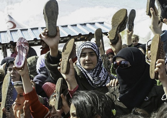 Syrian refugees holds up their shoes during a protest against Syria's President Bashar al-Assad at Reyhanli refugee camp in Hatay province on the Turkish-Syrian border March 15, 2012 by FreedomHouse2